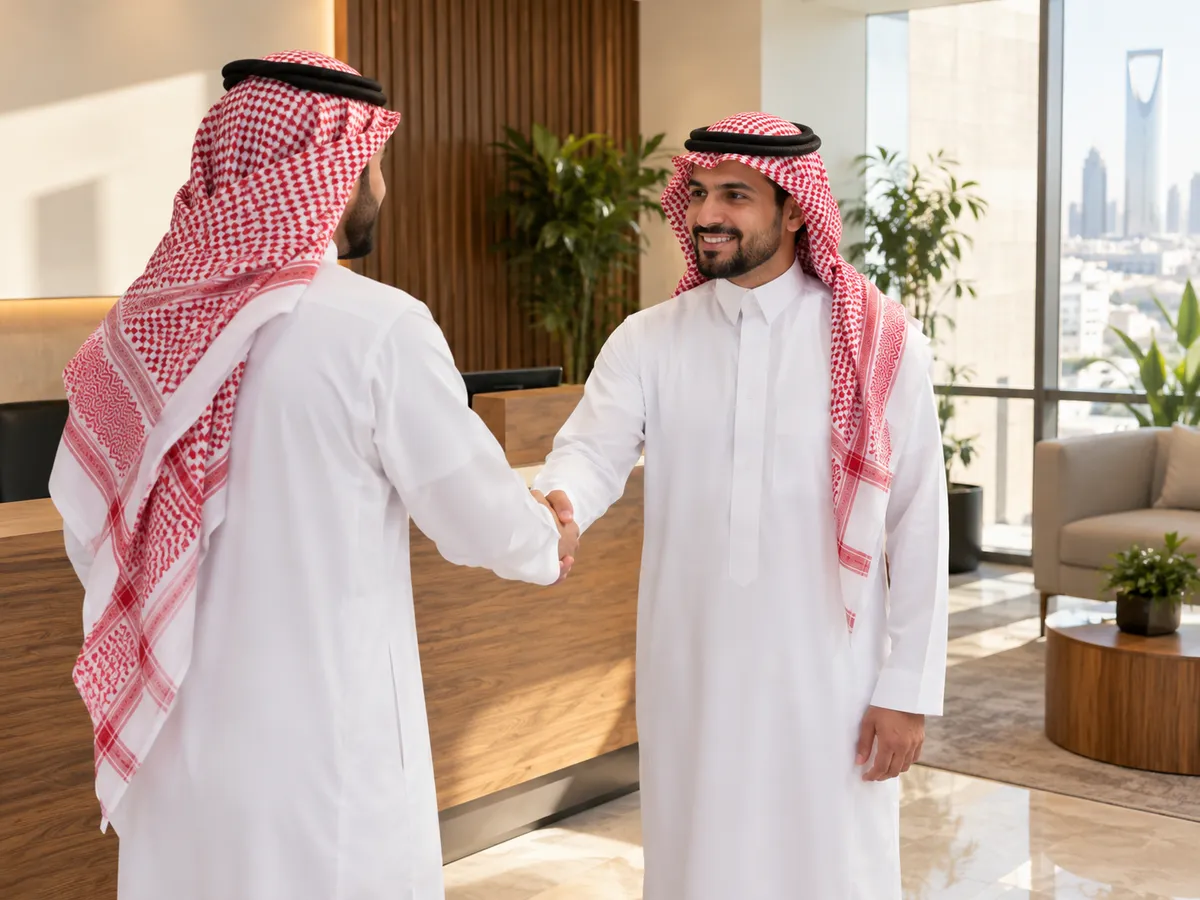 مكتب سداد قروض: مستشار سعودي يستقبل عميل بالمصافحة عند مدخل مكتب في الرياض